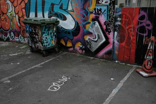 Graffitied wall and trash bin