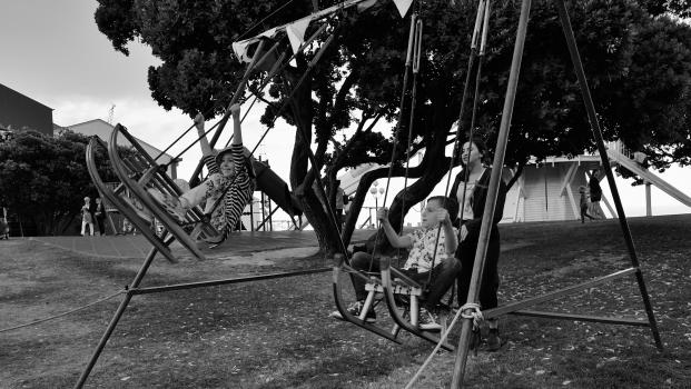 Children playing on sled swings black and white