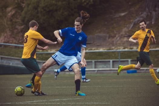 Soccer player in ponytail trying to get possession of ball - Sports Zone sunday league