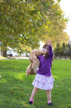 Child with Down syndrome carrying stuffed toy