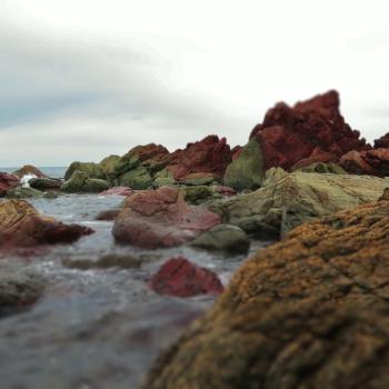 Natural red rocks and sea waves at Owhiro Bay