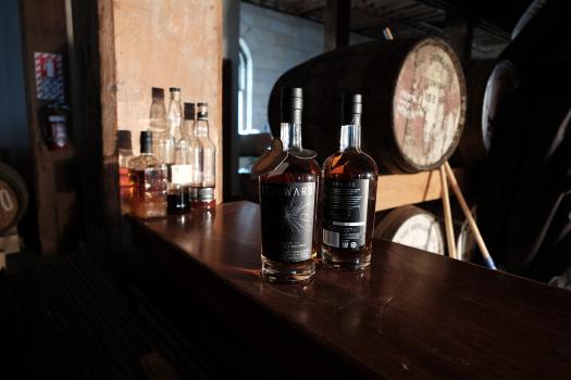 Starward whiskey bottles and barrels in a distillery bokeh