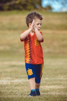 Boy in Manchester United kit clapping at Little Dribblers football match