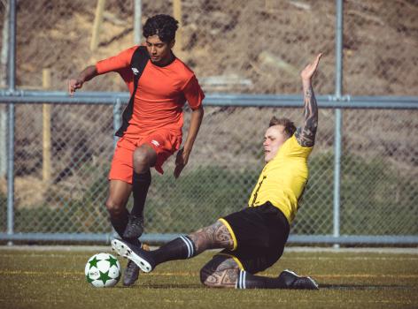 Tattooed player slide tackle another player - Sports Zone sunday league
