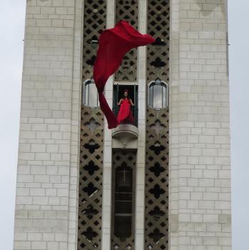 Woman in a tower waving her long red dress