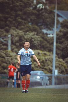 Smiling asian player await falling ball - Sports Zone sunday league