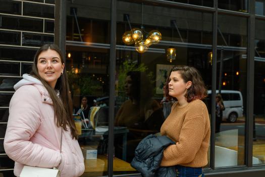 Young women chatting outside restaurant