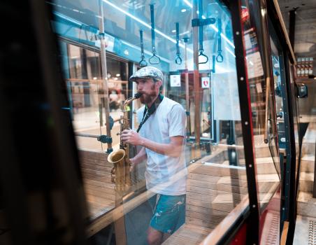 Musician reflected in cable car window