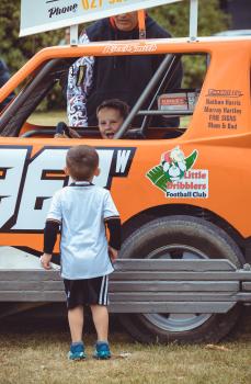 Kid inside orange race kart at Little Dribblers