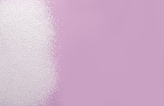 Left aligned stevia grains on pink background