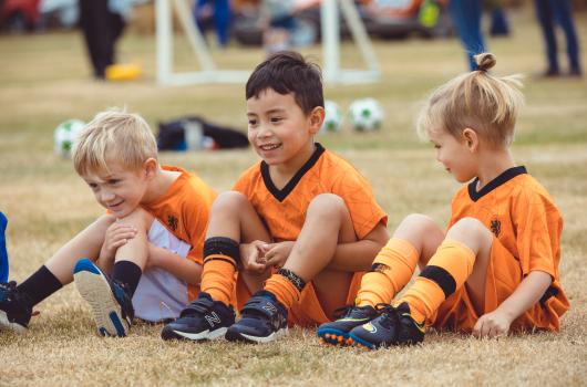 Two boys and a girl in Netherland kit at Little Dribblers football game
