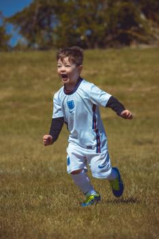 Boy wearing England kit running - Little Dribblers