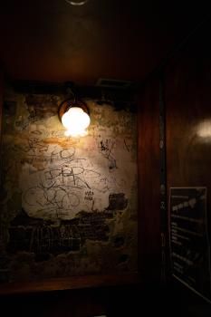 Graffiti on a tarnished wall in a dimly lit room