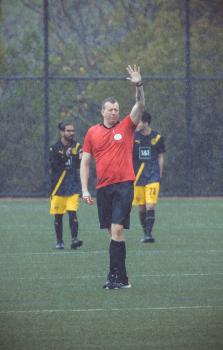 Player in red shirt raising hand in the rain - Sports Zone sunday league