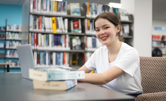 Smiling girl in library looking at you