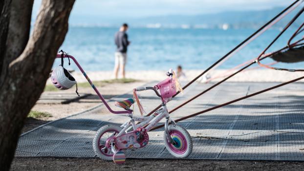 A little girl's bicycle and helmet at the beach