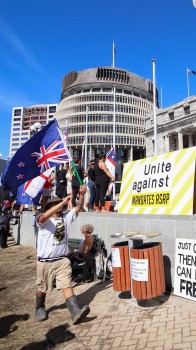 Man in wellies waving NZ flag - Convoy 2022