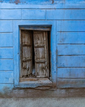 Broken wooden shutter and blue wall