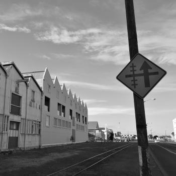 Warehouses and railway crossing sign at Hawkes bay black and white