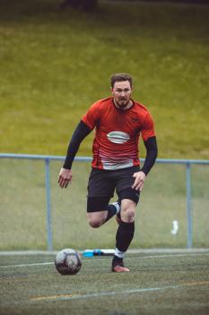 Player with black undershirt running after football T90 - Sports Zone sunday league