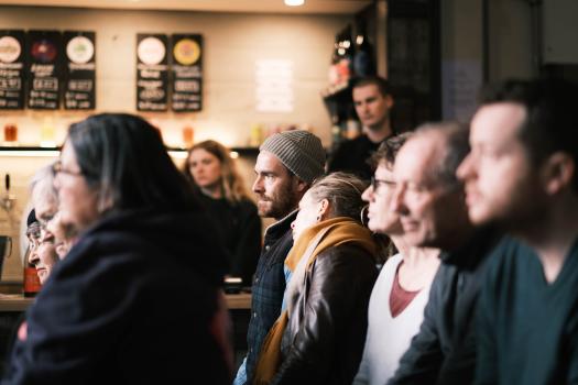 Group of people in a pub enthralled by a performance