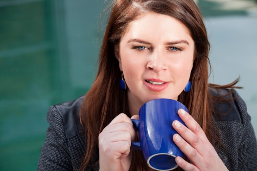 Brunette woman holds coffee mug