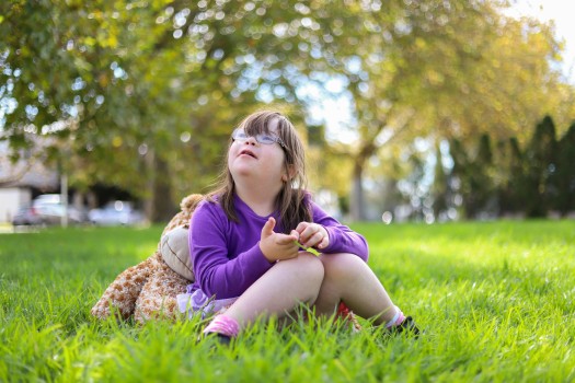 Child with Down syndrome playing outside