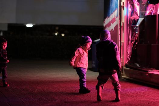 Children playing in pink light on pavement