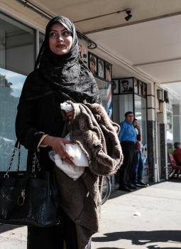 Muslim woman in black attire waiting on the street