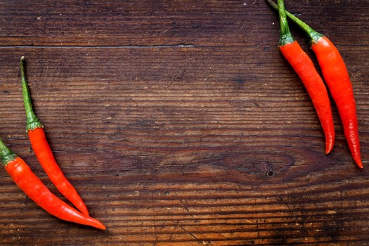 Red chilli peppers on a wooden table top