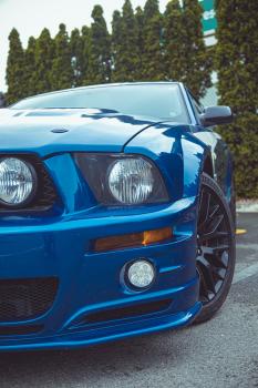 Blue Ford Mustang's headlight and alloy wheel
