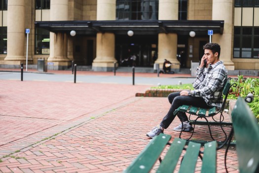 Guy sitting on a green bench outdoors