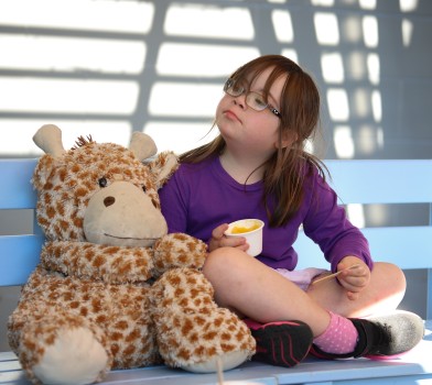 Youngster w/ Down syndrome sitting with toy