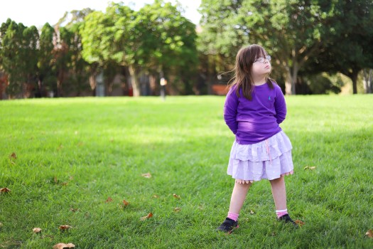 Child with Down syndrome standing on grass