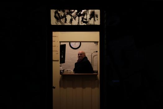Bald man inside a building at the counter