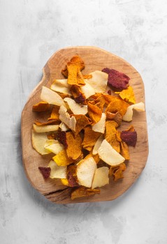 Potato chips on a wooden plate