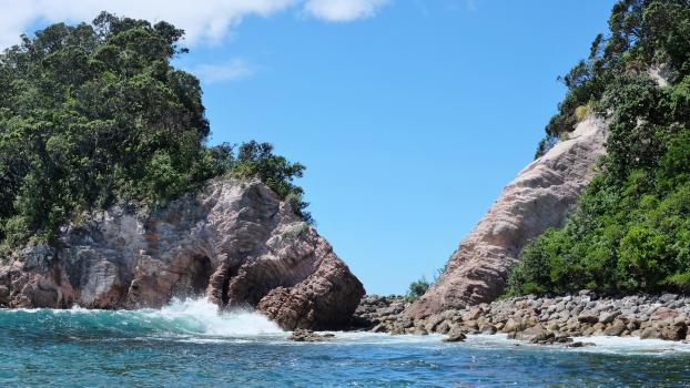 Blue water waves and a rocky shoreline at Coromandel