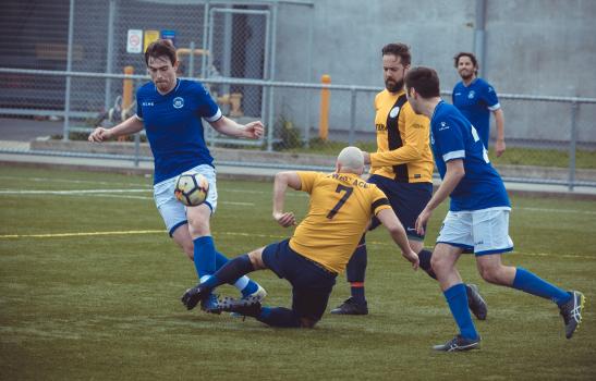 Player in yellow shirt slide tackles Frothers FC player - Sports Zone sunday league