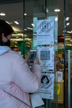 Young woman scanning in on Covid QR code