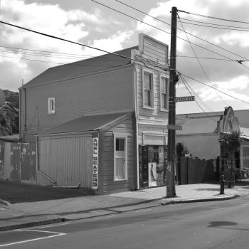 A wooden building and posters on Riddiford street in Newtown black and white