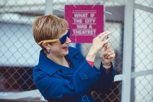 Woman in a blue trench coat holding a mobile phone