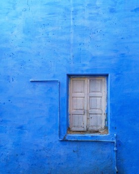 Blue coloured wall with window shutter