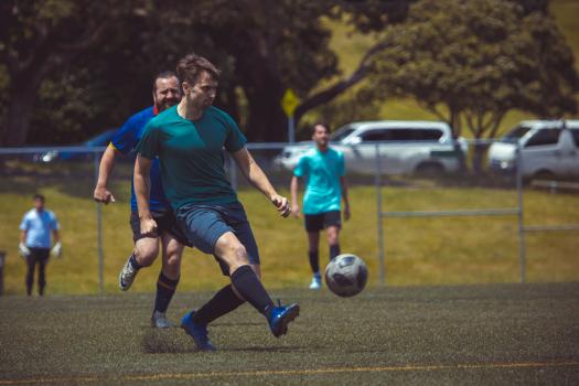 Player wearing plain teal shirt kicks football - Sports Zone sunday league