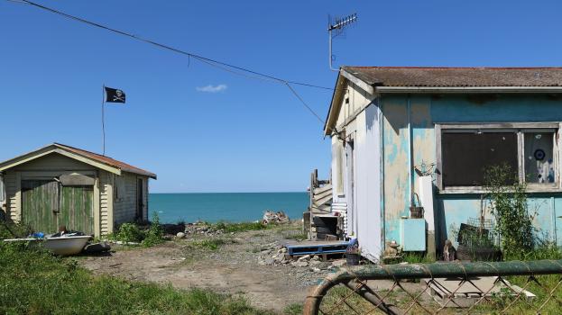 A beach house with a shack and pirate flag at Hawkes bay