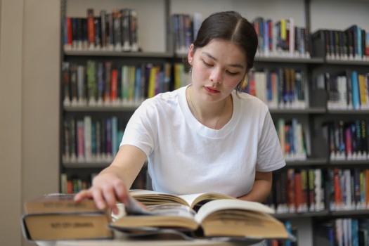 Young girl turning page of book