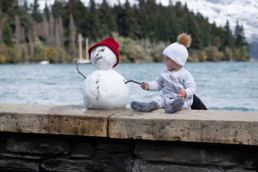 Baby making friends with a snowman