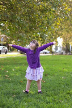 Young girl with Down syndrome arms wide open