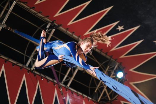 Female circus performer upside down on a fabric rope