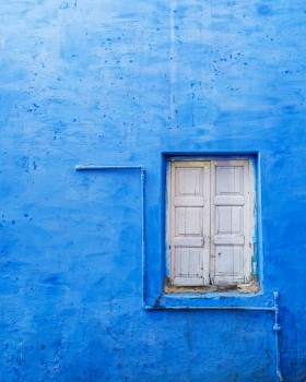 Blue wall with white wooden window