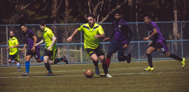 Player in lime neon Adidas shirt chased by opponents - Sports Zone sunday league